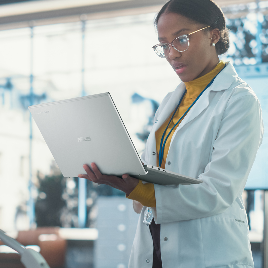 A female researcher is holding an ASUS Chromebook and looking at it